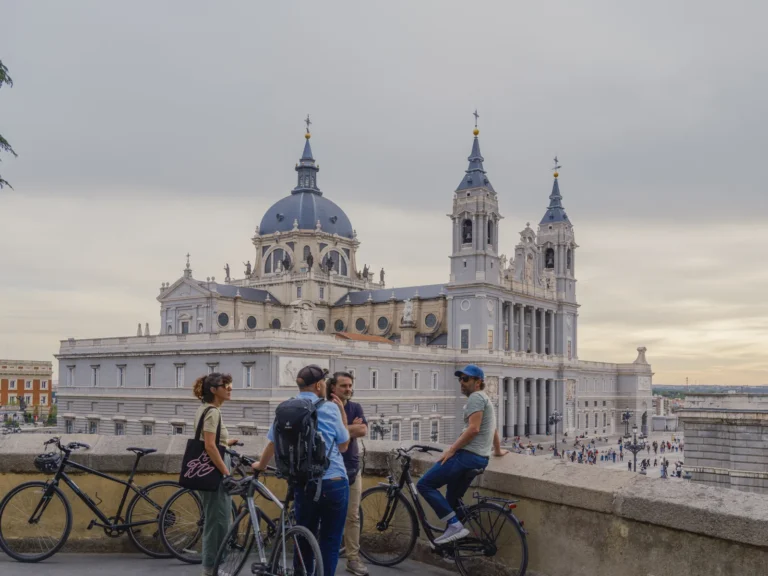 Hidden Madrid bike tour 15 Group of cyclists with bikes admire the Almudena Cathedral from the viewpoint during the Hidden Madrid bike tour