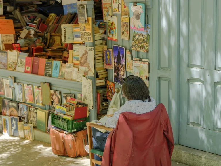 Historic Madrid Walking Tour 2 Visitor in orange coat browsing antique books at an El Rastro vendor stall on a Dinamo Historic Madrid Walking Tour