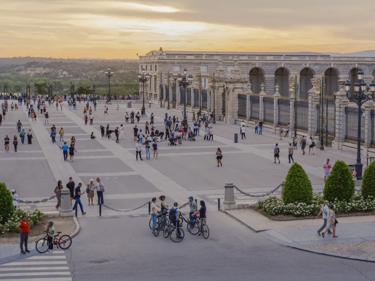Private Madrid Bike Tour 3 Small group with bikes pauses on the Royal Palace esplanade at sunset on a private Madrid bike tour
