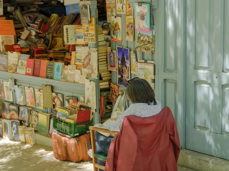 Private Madrid walking tour 7 Visitor in a red jacket browses antique books at an open-air stall on a private Madrid walking tour