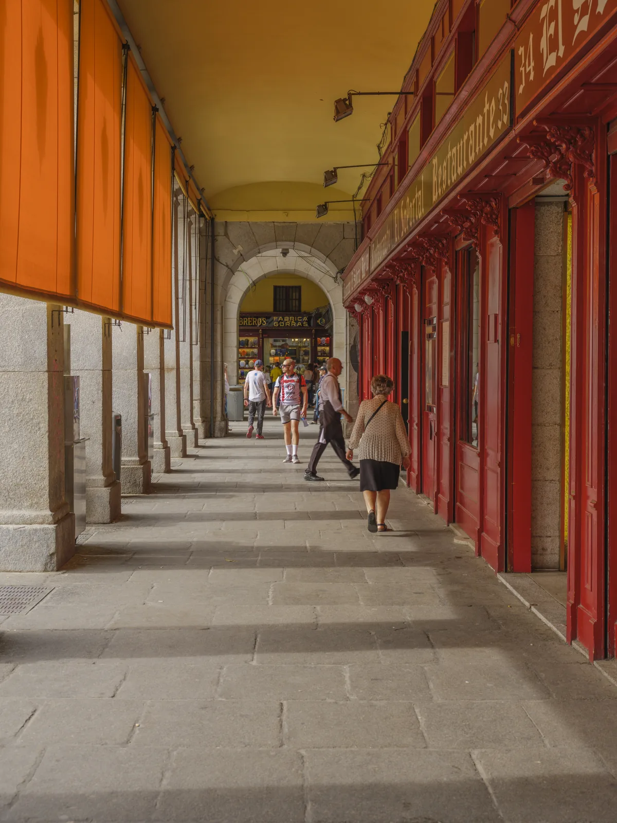 madrid in 3 days 1 Arcade of Plaza Mayor in Madrid with orange awnings and red shopfronts along the covered walkway
