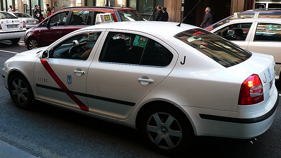 madrid airport to madrid centre 4 A white Madrid taxi with the red stripe and the city coat of arms on the door