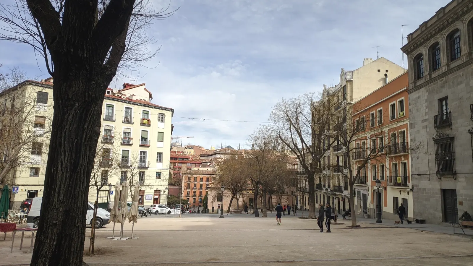 where to stay in madrid 3 Plaza de la Paja in La Latina on a quiet morning, a bare tree in the foreground and old façades around the sloping square