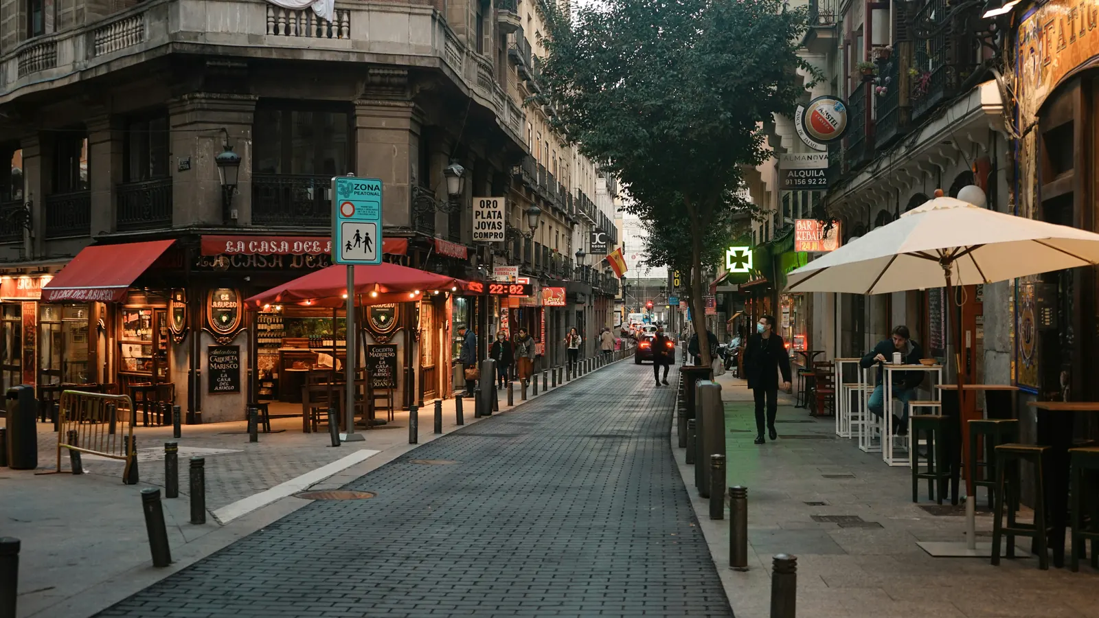 where to stay in madrid 1 Where to stay in Madrid: a pedestrianised tapas street near Plaza de Santa Ana at dusk, with terraces and bollards