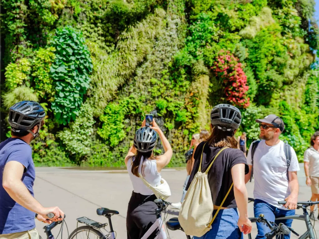 unusual things to do in Madrid 18 Riders in helmets stop to photograph the vertical garden wall of CaixaForum, on bike tours in Madrid, Spain