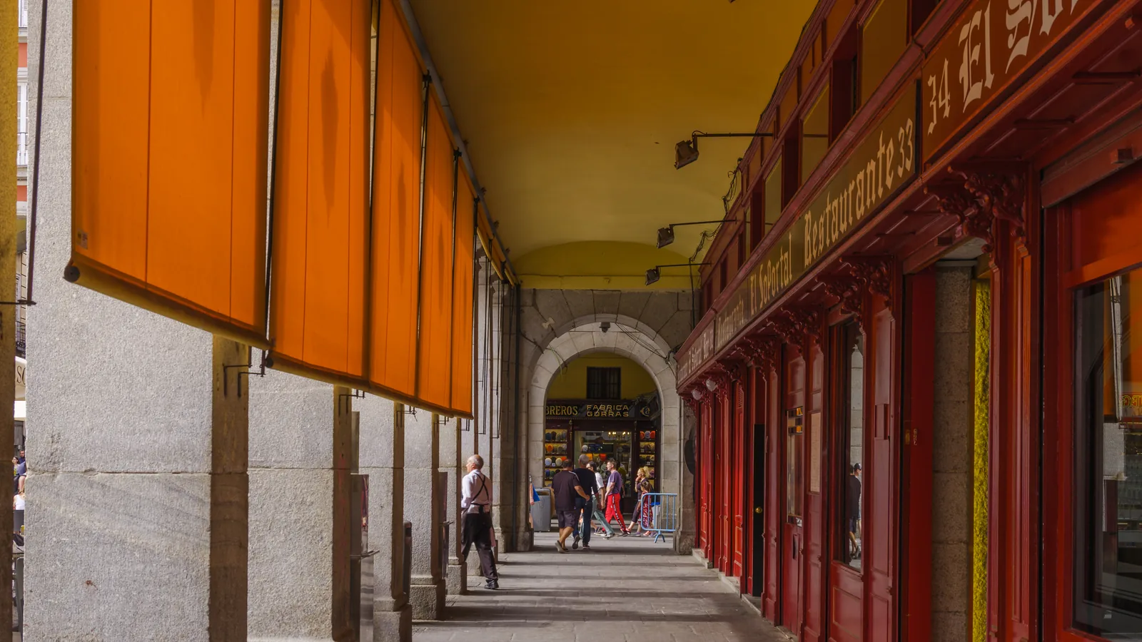 madrid souvenirs 3 Arcades of Plaza Mayor, Madrid, with orange awnings and the red shopfronts of the old trades