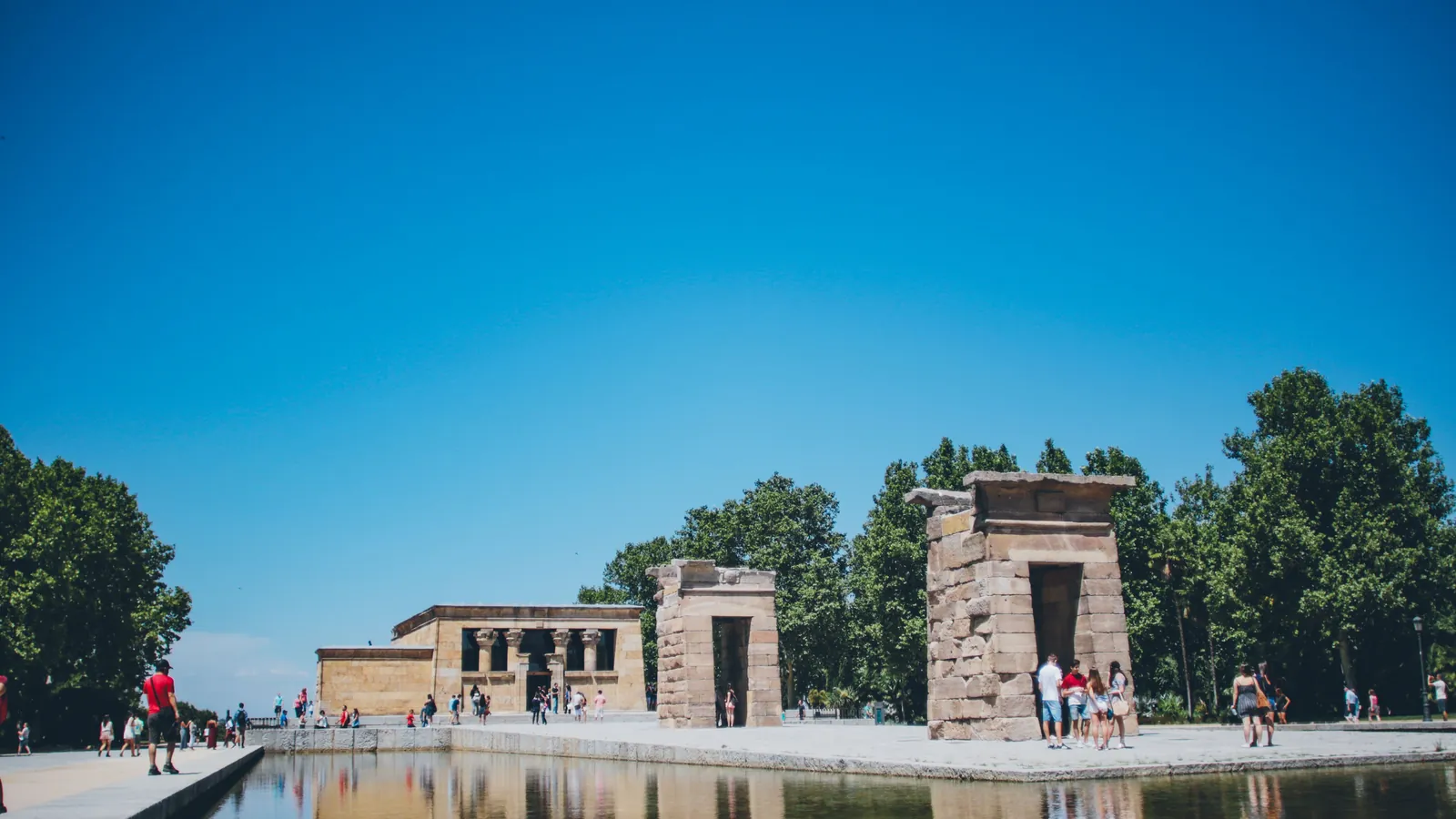 things to do in madrid by bike 1 Temple of Debod on a clear morning, its stone gateways reflected in the pond, with hardly anyone around