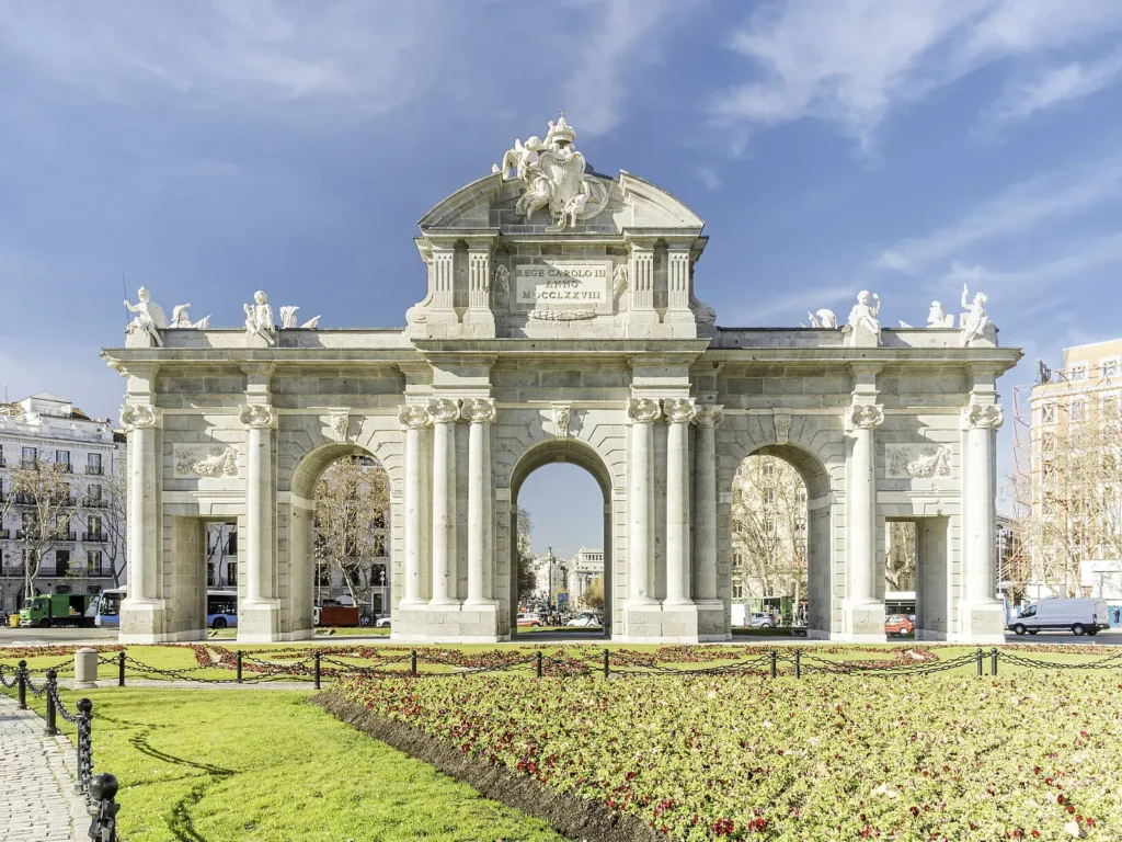 unusual things to do in Madrid 20 The Puerta de Alcalá and its flowerbeds under a clear winter sky, a stop we ride to in groups of eight.